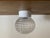 Vintage flush mount ceiling light dating from the 1970s, featuring a thick clear pressed glass shade with a distinctive...