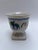 A single antique round porcelain cup with square foot featuring gilt trim and decoration including flowers and fruit.