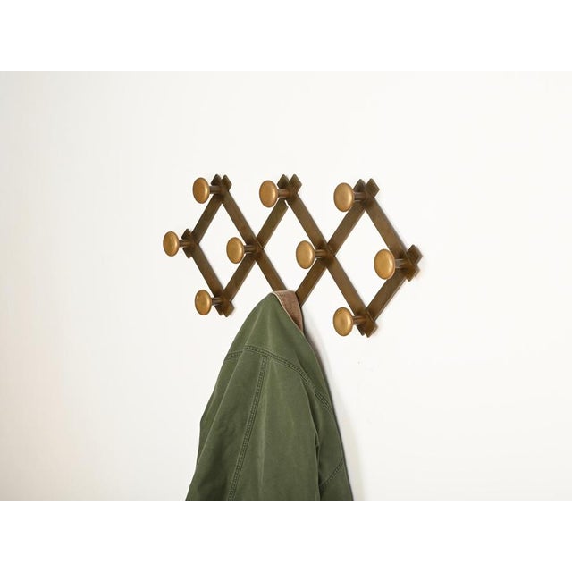 Spectacular Italian expandable wall coat rack entirely made in heavy solid brass. This refined and unique piece was...