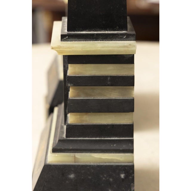 This is a handsome pair of Egyptian Revival obelisks crafted in black stone and richly decorated with brass and mother-of-...
