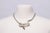 A condensed herringbone pattern snake chain necklace with a coiled snake at the front with faceted garnet eyes and a...