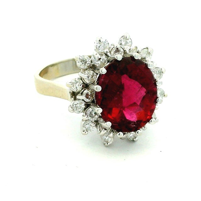 Vintage 14K white gold ring featuring a vibrant oval pink tourmaline, approximately 4.65 carats, surrounded by a halo of...