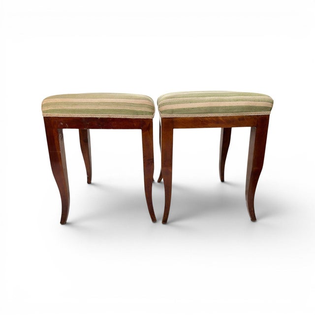 Crafted from richly patinated walnut, this elegant pair of French Directoire stools features clean lines, tapered legs,...