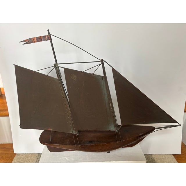 A copper and wood Clipper Ship Weathervane, now mounted on a block of wood for indoor display. The wood hull appears to be...