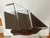 A copper and wood Clipper Ship Weathervane, now mounted on a block of wood for indoor display. The wood hull appears to be...