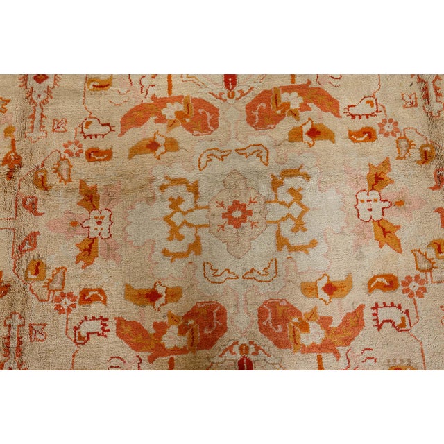 This exquisite antique Turkish Oushak rug, woven circa 1900, is a masterful example of Anatolian craftsmanship at the turn...