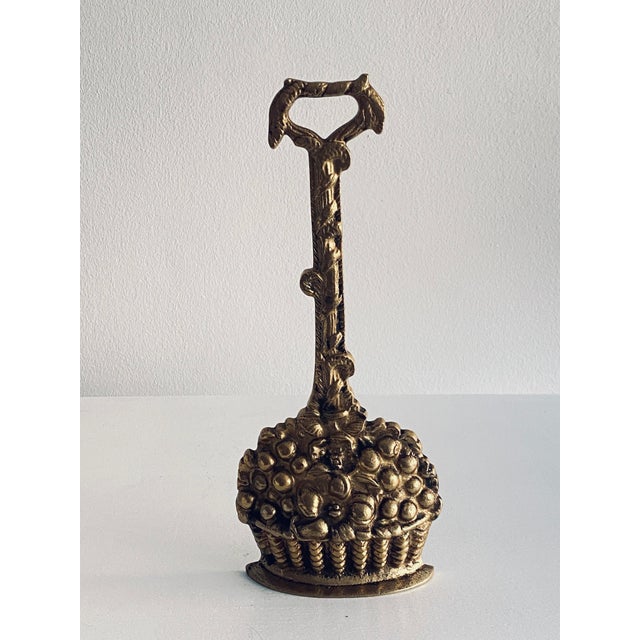 A beautiful doorstop made of solid brass, shaped like a harvest basket filled with fruit, flowers, and ears of grain....
