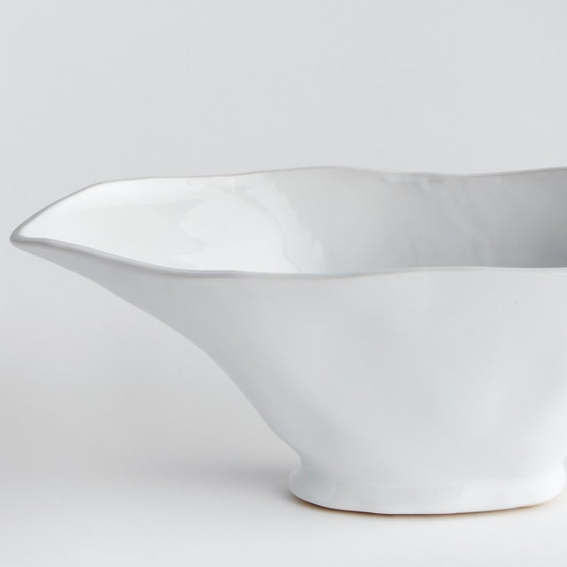 With a sculptural form and slim profile, this vase is made for narrow console or mantle. Drape a faux stem or two along...