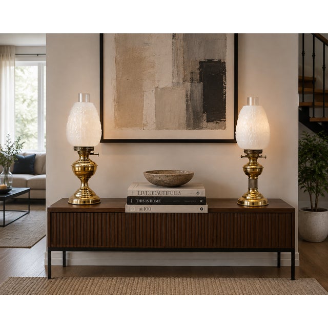 A decorative near pair of antique Edwardian oil lamps dating to circa 1900, each with a polished brass reservoir and...