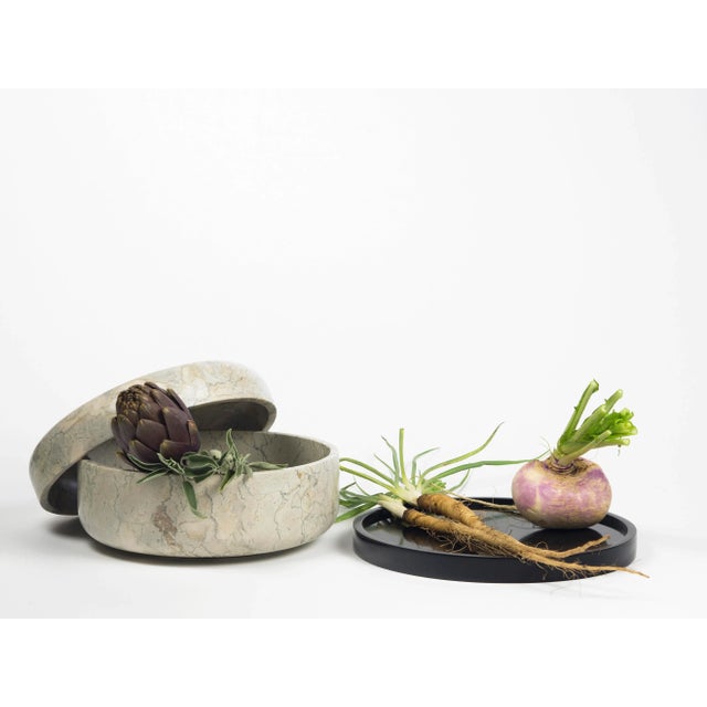 This collection of marble containers made up of two elements and held together by a Corian element is designed for...