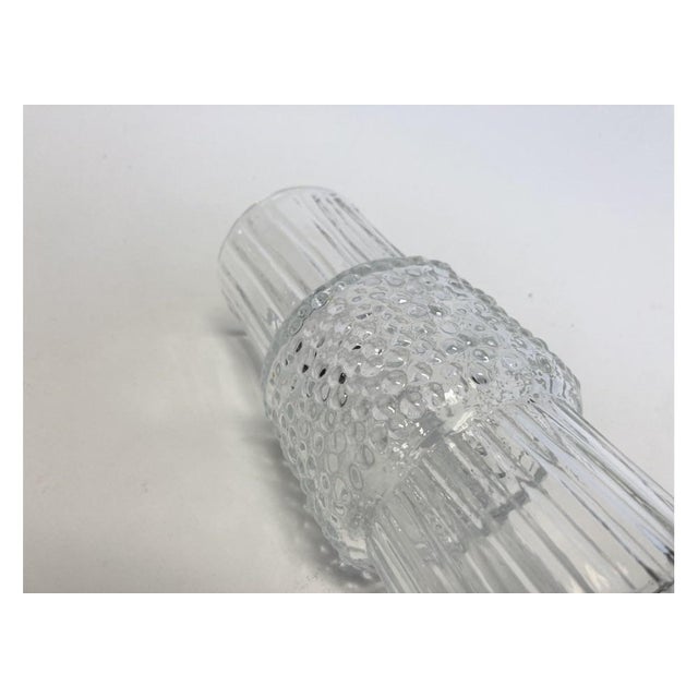 A Vintage clear glass vase with good weight and great Mid Century style. The ribbed glass vase has a wider beaded mid...