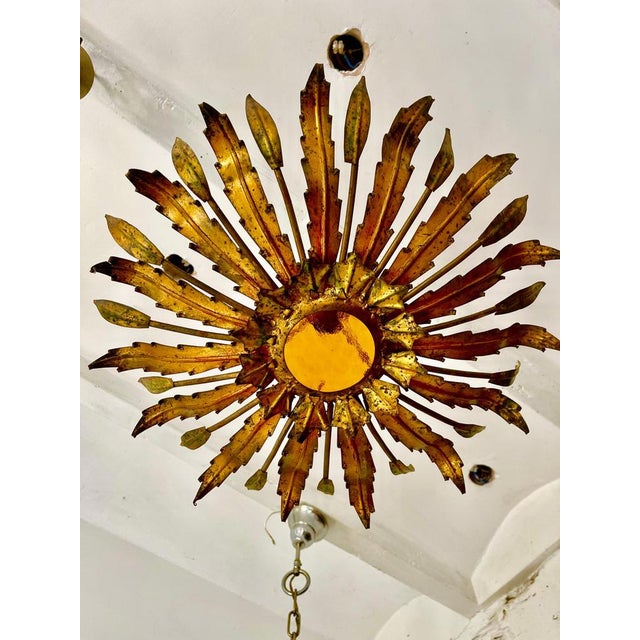 Spain, 1950s. Midcentury antique gilt iron frame or pendant with laurel leaf motifs surrounding a central frosted glass...