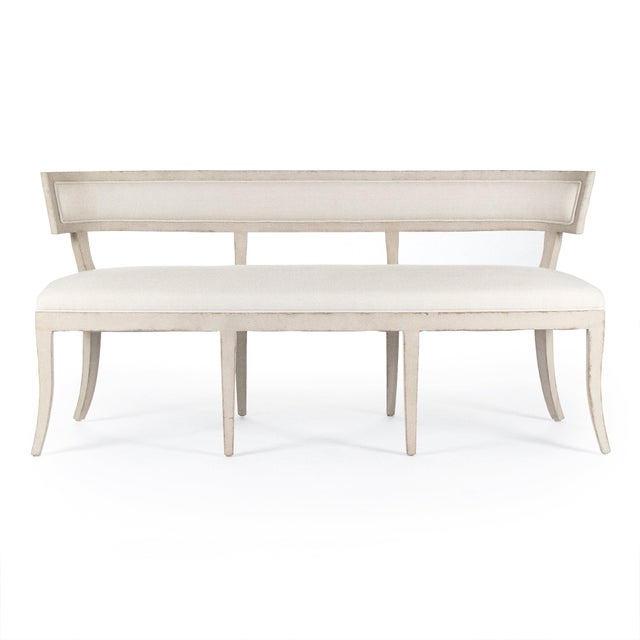 The Lorand Bench from Zentique is a French Louis XVI settee with a carved flat-back frame, scrolled arms, off-white linen...