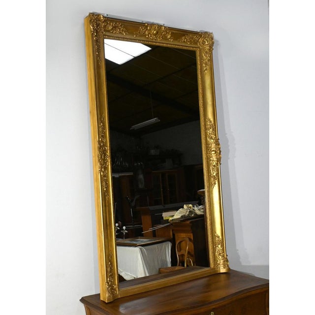 This important rectangular gilded leaf mirror, in the Louis XIV style and dating from the mid-19th century, is a...