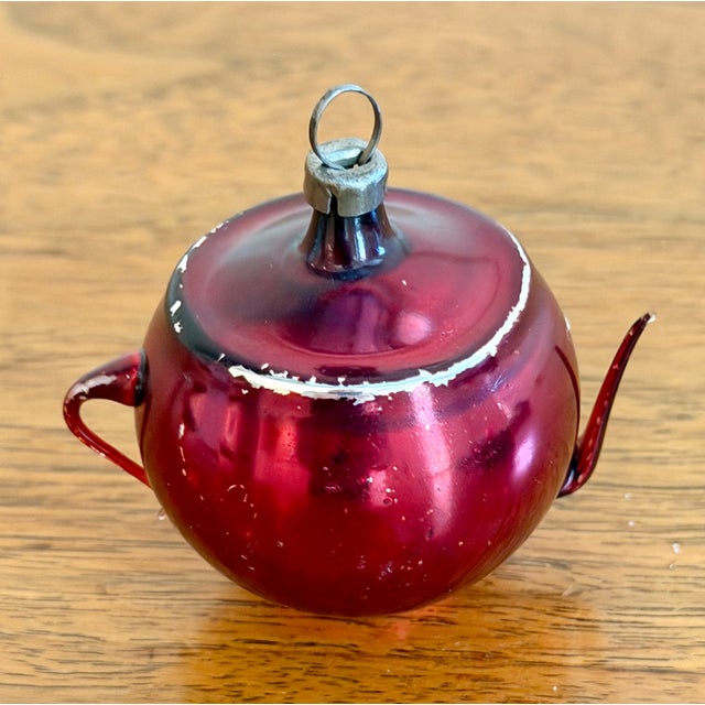 Delicate antique mercury glass teapot ornament in shiny dark red and etched or painted silver floral motif and with thin...