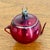 Delicate antique mercury glass teapot ornament in shiny dark red and etched or painted silver floral motif and with thin...