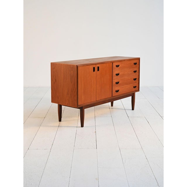 Teak sideboard with two hinged doors and four drawers. Danish production from the 1960s. This 1960s Danish teak sideboard...
