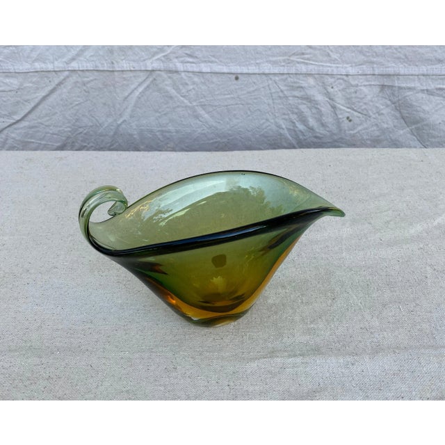 A very interesting Murano hand blown bowl with green and gold layers. The top is finished by a graceful swirl that offers...