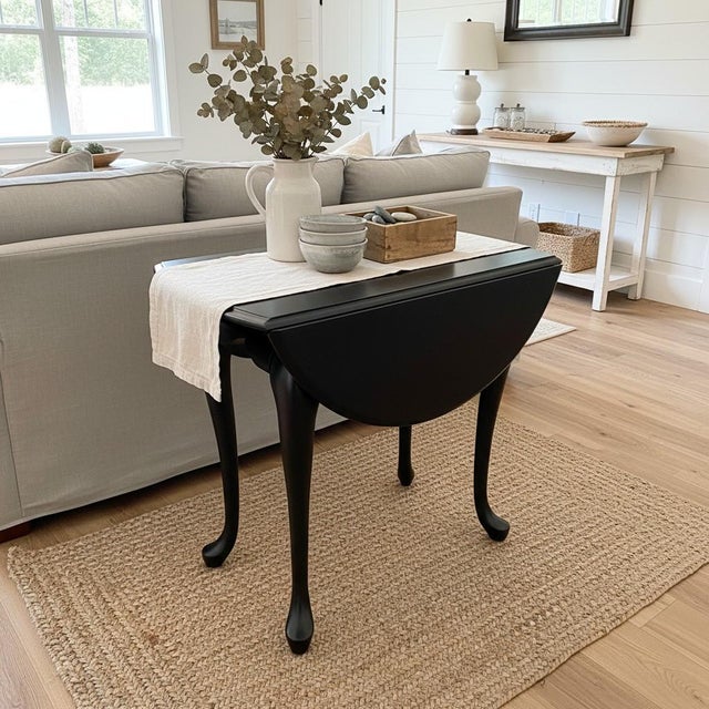 A graceful Queen Anne–style drop leaf table, thoughtfully restored and finished in a rich matte black that lends a modern...