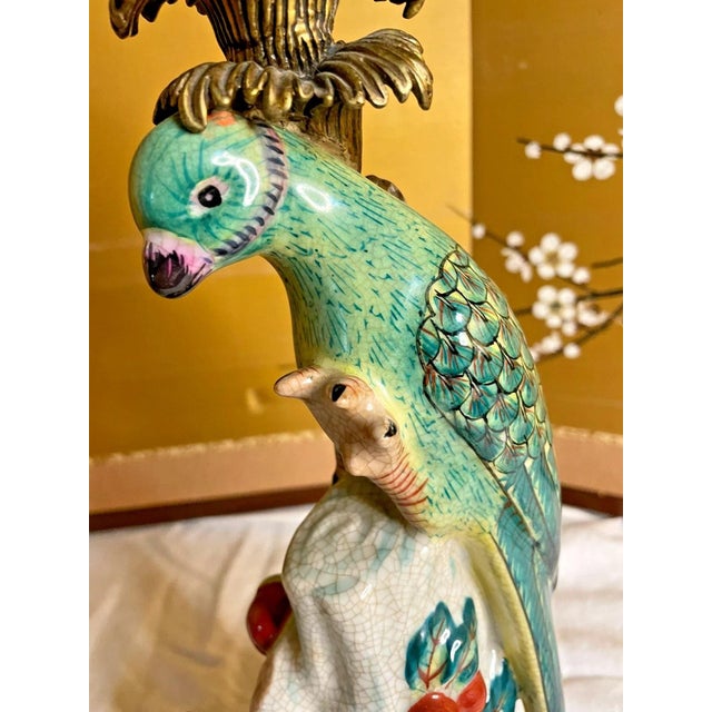 Bring a vibrant splash of Hollywood Regency elegance to your home with this beautiful vintage porcelain parrot...