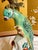 Bring a vibrant splash of Hollywood Regency elegance to your home with this beautiful vintage porcelain parrot...