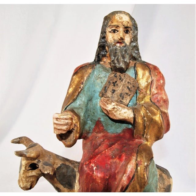 A wonderful antique wood carved Santos of St. Luke with a steer. Luke is often shown with an ox or a calf because these...