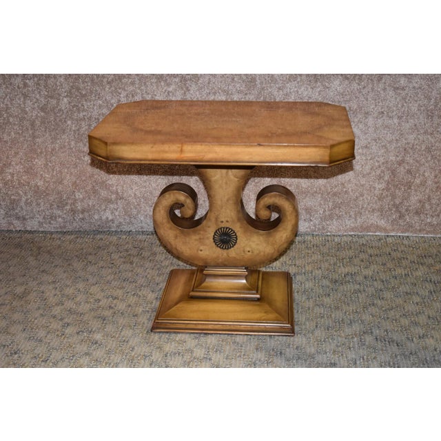 Vintage accent table with pedestal has a neoclassic style. The table is made of wood and has an inlaid burl top. The...