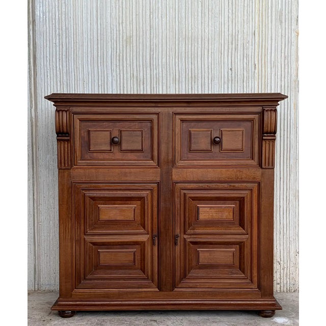 From Northern Spain, constructed of solid walnut, the rectangular top with molded edge atop a conforming case housing two...