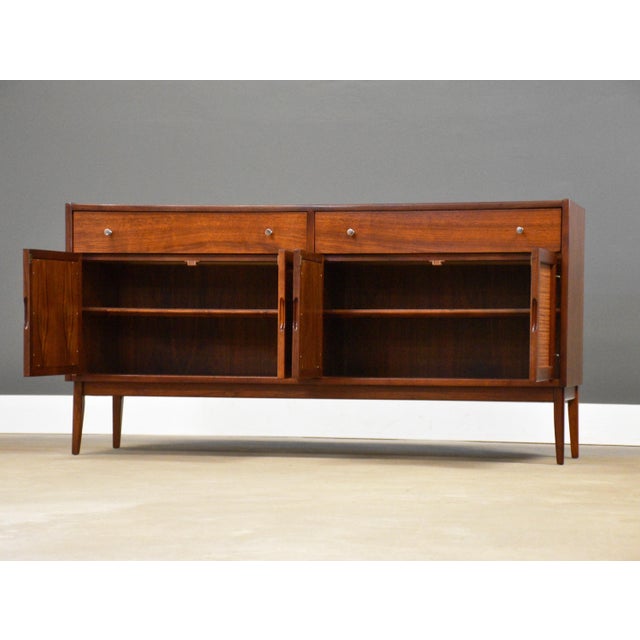 A mid century modern walnut tv console credenza with four cane doors designed by Jack Cartwright for Founders....