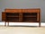 A mid century modern walnut tv console credenza with four cane doors designed by Jack Cartwright for Founders....