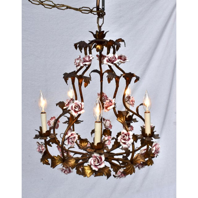 An exquisite patinated bronzed antique gold gilt Tole chandelier with 32 intricately hand crafted pink porcelain roses....