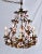 An exquisite patinated bronzed antique gold gilt Tole chandelier with 32 intricately hand crafted pink porcelain roses....