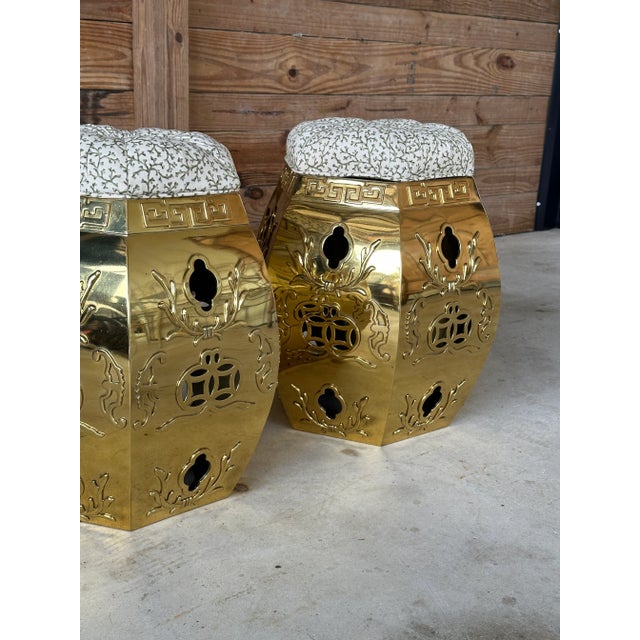 A striking pair of vintage brass Chinese garden stools featuring pierced and embossed decoration throughout. Each...