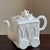 Offering a late-20th century Lenox porcelain teapot in the form of an elegant tea cart, complete with sculptural wheel...