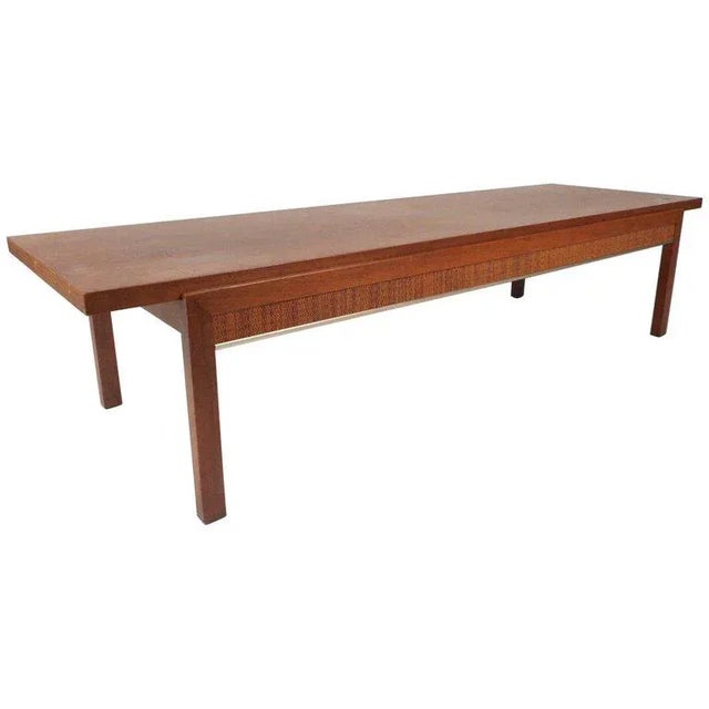 This stunning vintage modern coffee table features cane sides and a gorgeous walnut finish. Unique design with an...