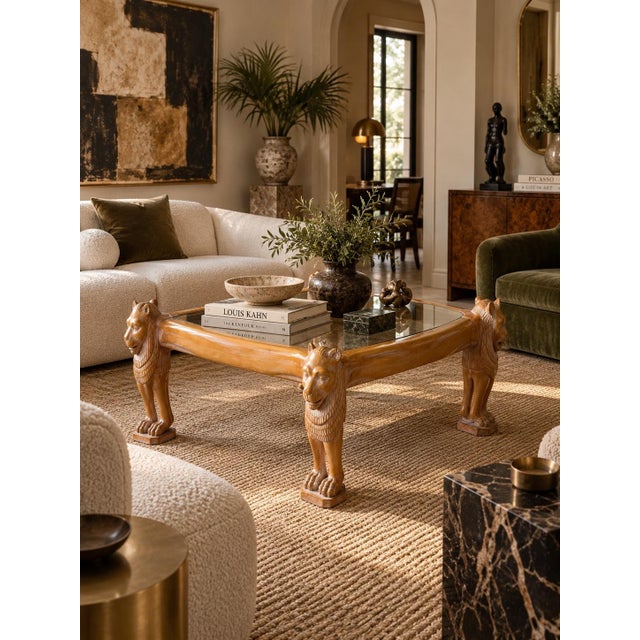 Striking vintage Egyptian Revival coffee table featuring a sculptural hand-carved wood frame supported by four impressive...