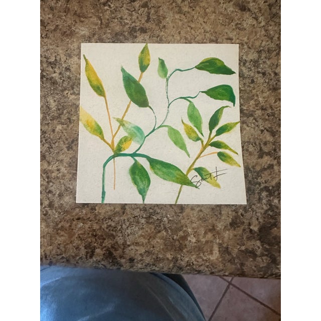 Delicate golden stems with lush green foliage painted on toned paper, offering a warm, natural elegance.