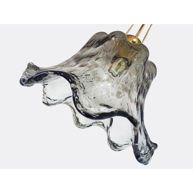 Elegant stylized flower pendant light with grey handblown murano glass on a brass frame. Chandelier illuminates...