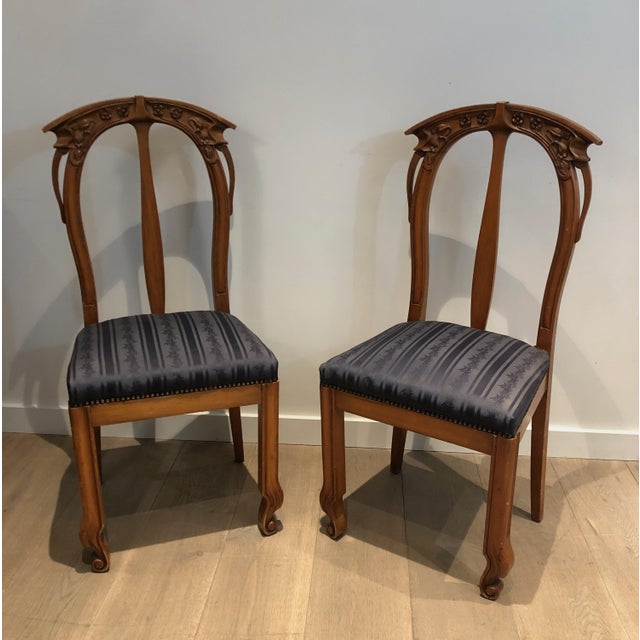 This lovely set of 4 chairs is made of cherry wood and decorated with flowers and plants. It is a French work from the Art...