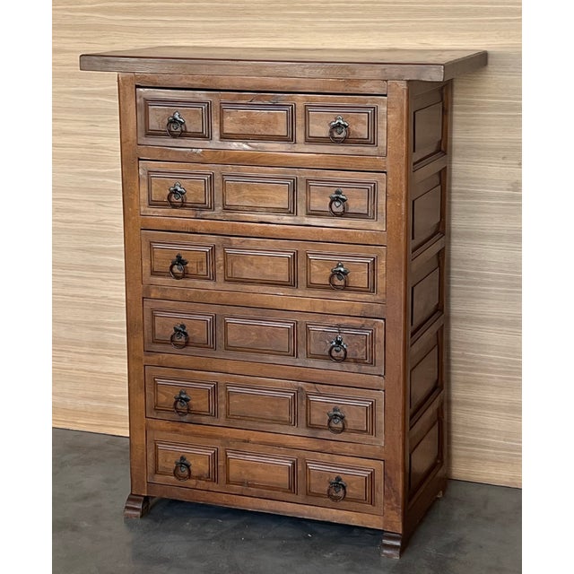 From Northern Spain, constructed of solid walnut, the rectangular top with molded edge atop a conforming case housing six...