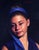This oil painting depicts a young girl with a serene expression, her gaze softly averted. The deep blues of her headband...