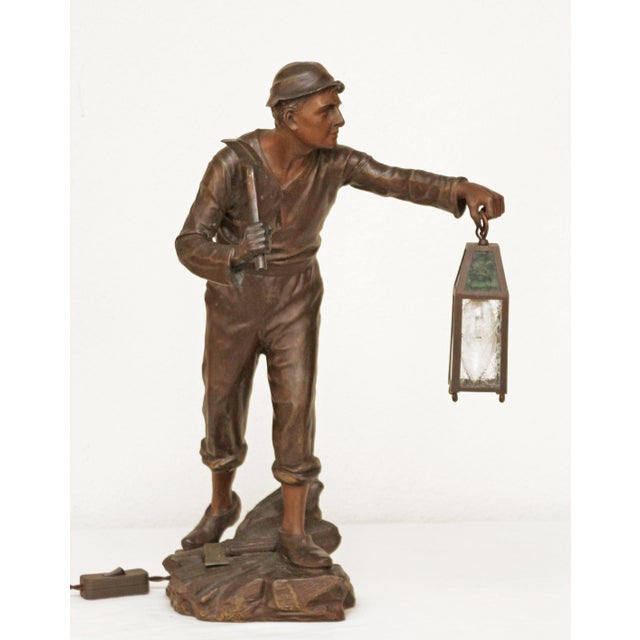Miner Large Art Nouveau metal figure, circa 1900. Miner with axe and lantern on a naturalistically designed background....