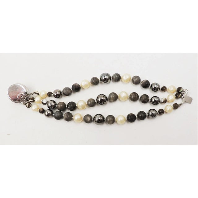 This is part of Chairish’s Costume Jewelry assortment. 1950s rhodium plated faux-hematite cabochon clasp and center beads...