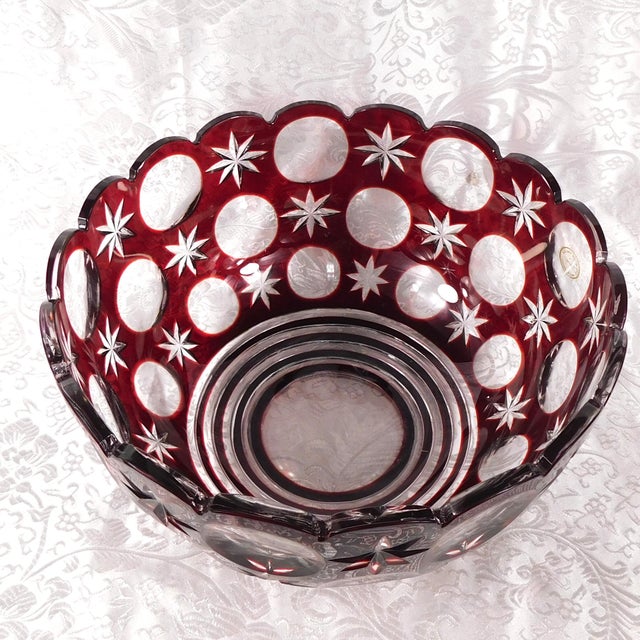 This is a larger red cut to clear bowl with a design of cut to clear circles and star patterns. The bowl has a fluted rim,...