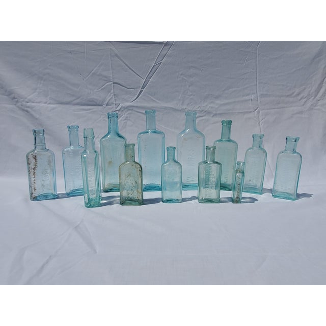 Cohesive group of 13 Aqua Colored Apothecary Medicine Bottles. late-1800s to early-1900s aqua glass A few earlier hand-...