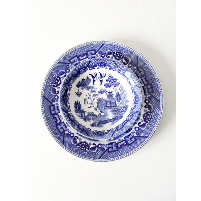 A set of vintage Japanese Blue Willow dishes featuring the classic blue willow pattern in cobalt on a crisp white ground....
