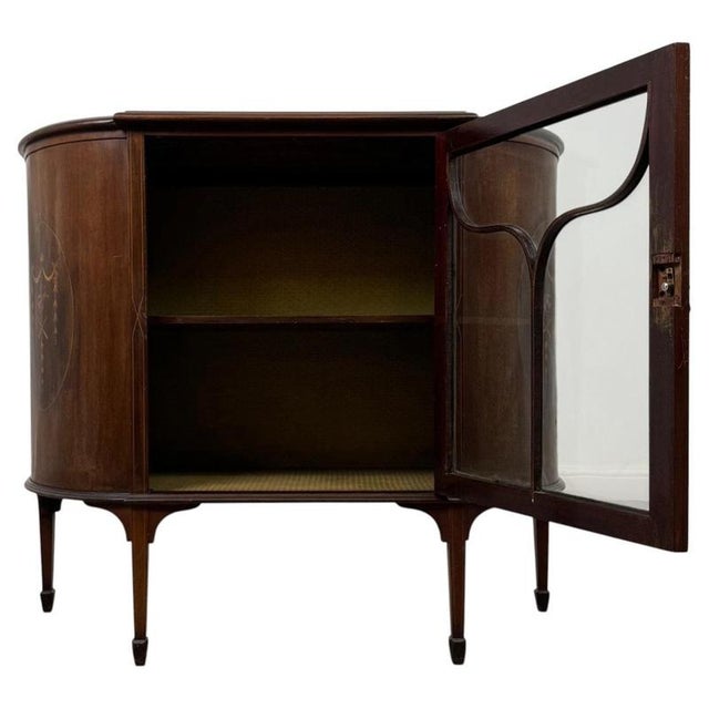A beautifully crafted early 20th-century English Edwardian display cabinet, finely constructed in mahogany and...