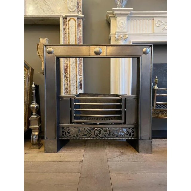 A Georgian style register grate in polished steel. The shaped bars with spherical spacers, flanked by plain panels with a...