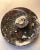 Polished black marble stone fossil round plate/bowl made from orthoceras sea shells with a single raised ammonite ring in...