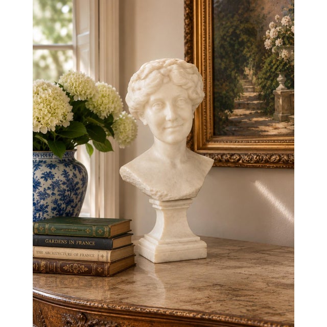 A beautifully carved Carrara marble bust of a young woman, created in France during the 1920s and signed by sculptor Paul...
